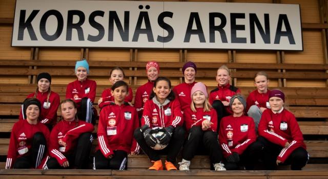 Vinnande laget på en läktare iklädda röda speldräkter. Ovanför dem står det KORSNÄS ARENA på en skylt.