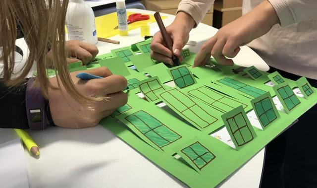 Händerna av två barn som pysslar.